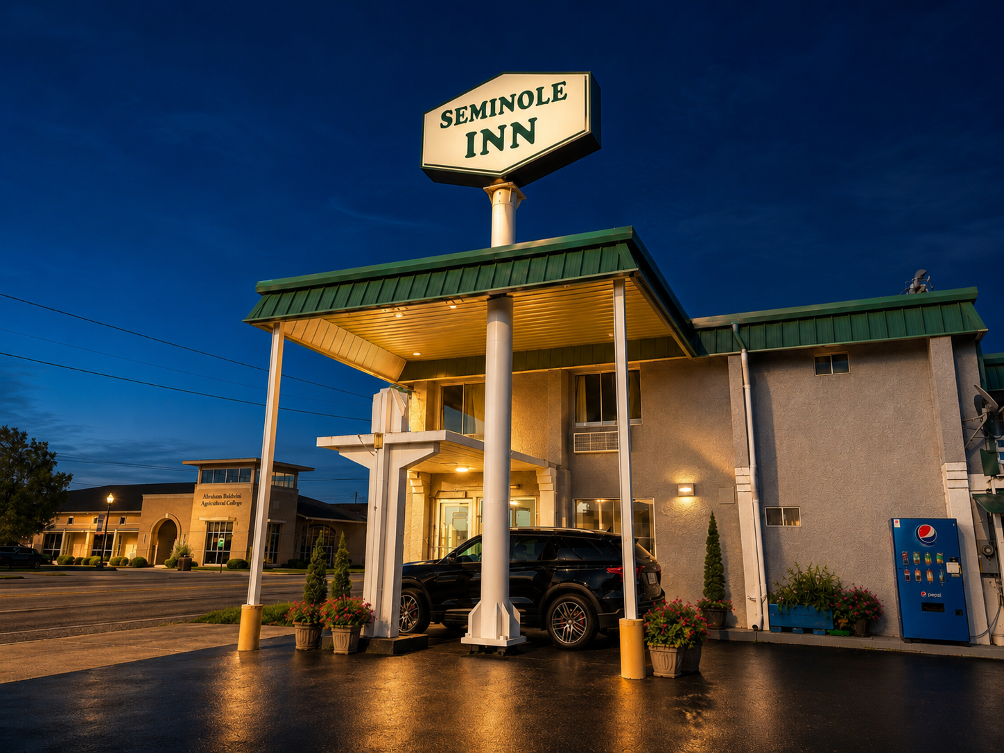 Seminole Inn exterior at night with lights on and the motel sign illuminated
