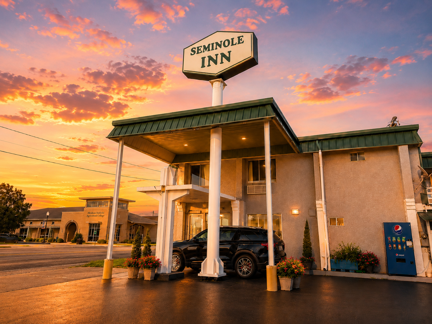 Seminole Inn exterior at sunset — the motel sign and covered walkway lit by a warm evening sky